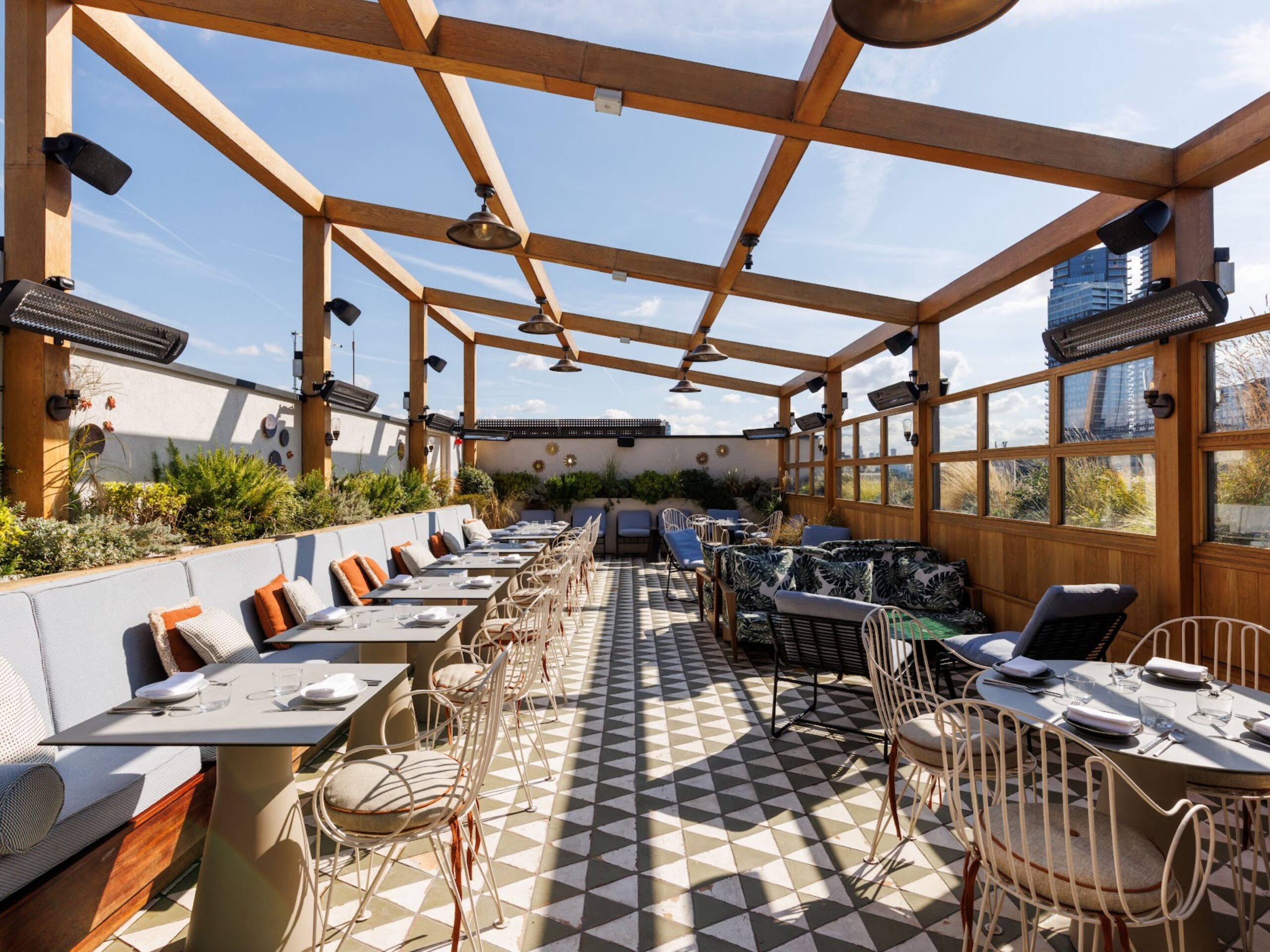 Llama Inn rooftop, with the ceiling open and furniture set up for casual drinks and food