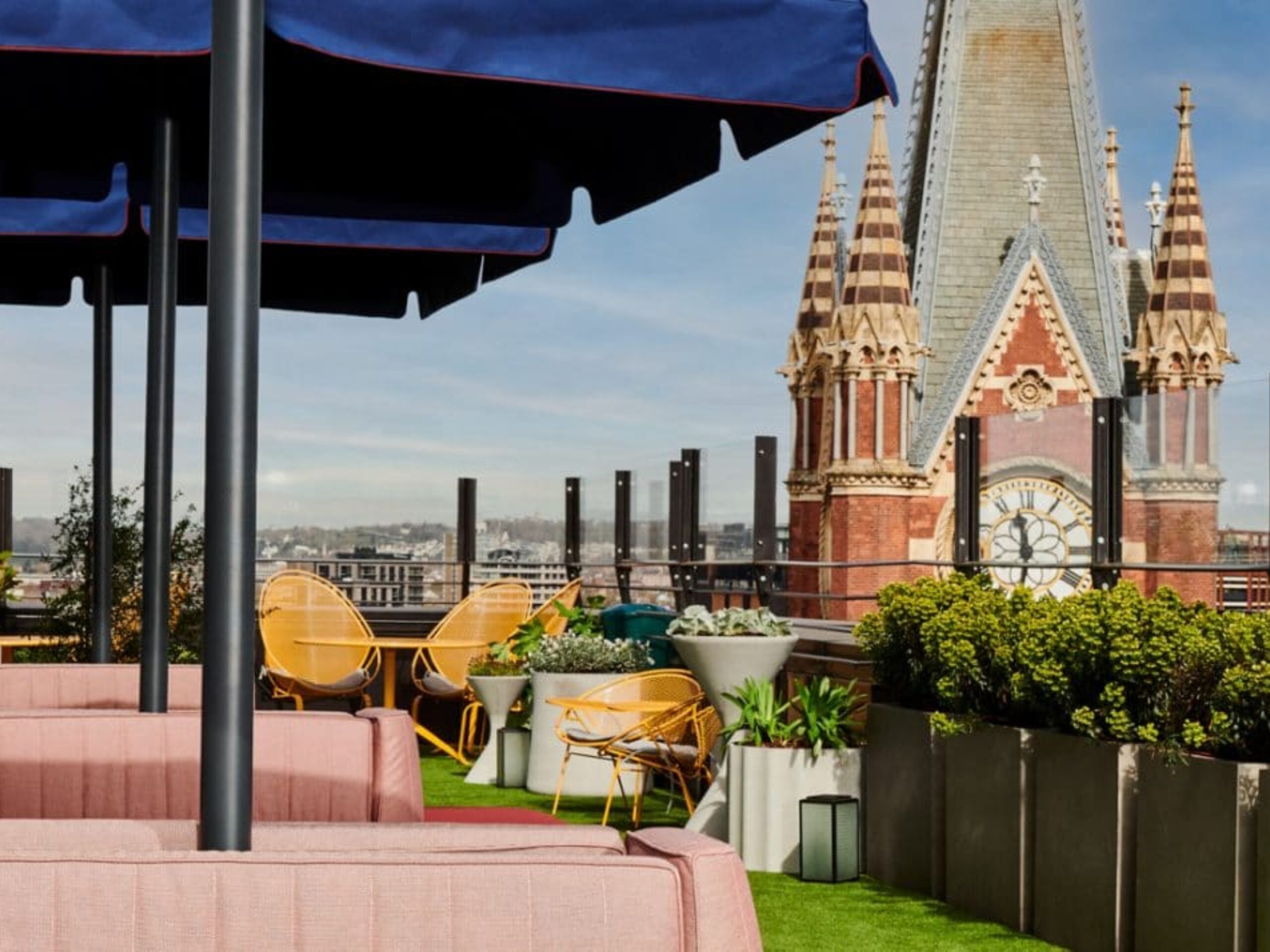 Seating and umbrellas set up on a sunny day at The Rooftop at The Standard, ready for a corporate summer party