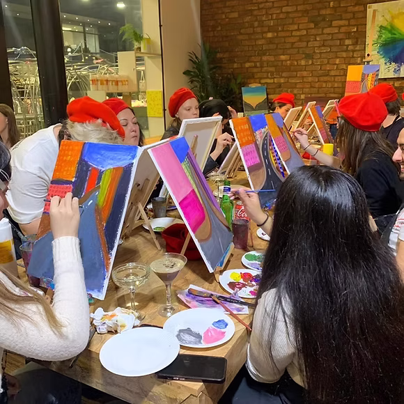 A group enjoying a paint and sip experience at Art Play in a relaxed and fun environment