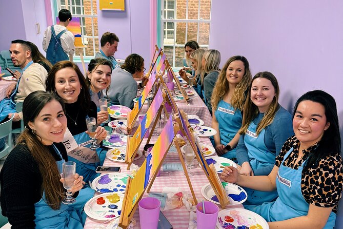 A group posing for a photo after enjoying a paint workshop at Brush and Bubbles