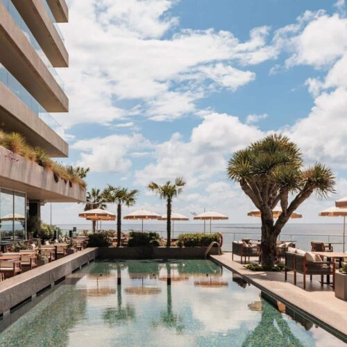 The main pool area at Saccharum, surrounded by deck chairs and umberellas