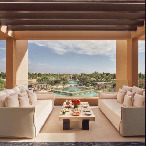 A private balcony off a room at Mandarin Oriental, with two sofas and looks out onto the pool area