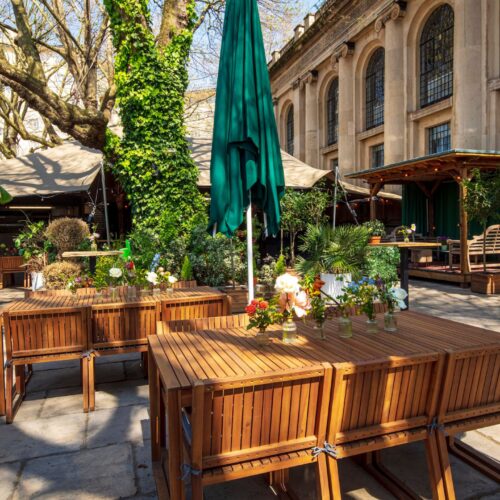 Tables set up for a garden summer party in One Marylebone's outdoor area