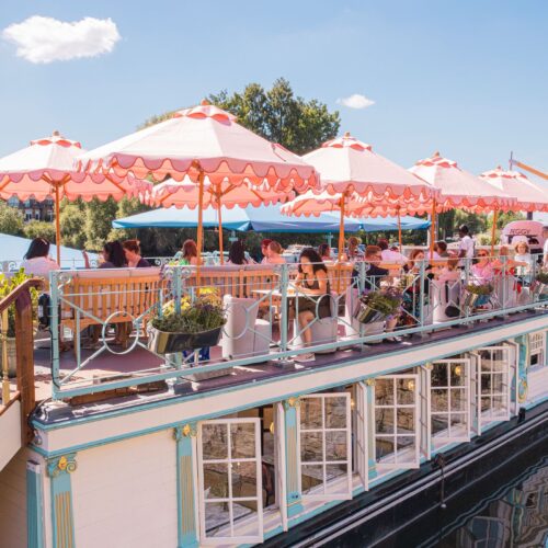 The Peggy Jean boat in richmond in the sun, with bright pink umberellas on the top deck to protect guests from the sun