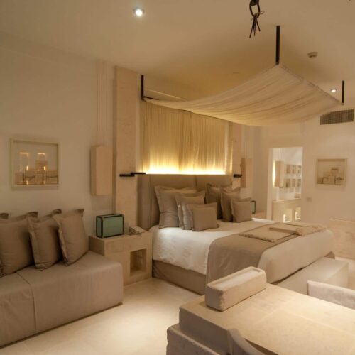 A bedroom at Borgo Egnazia, decorated with neutral tones and soft linens