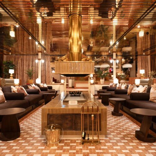 A indoor bar in Hjortviken Country Club, with dark, orange decorations and sofas