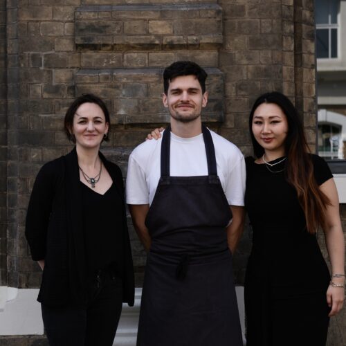 The team behing Lady of the Grapes posing for a group photo in front of the restaurant exterior