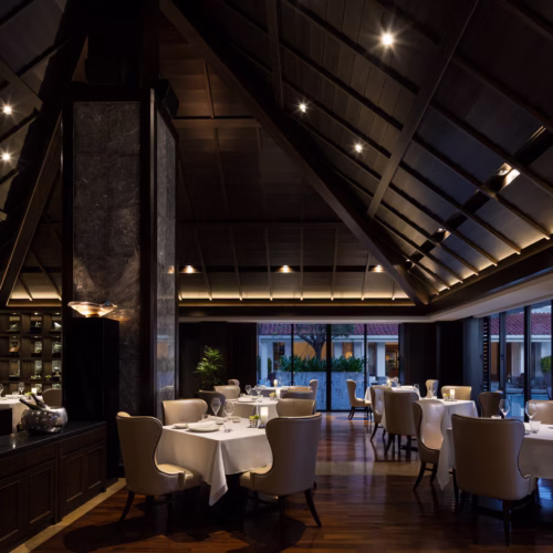 The main restaurant at The Ritz-Carlton at night, lit with dim and romantic lighting