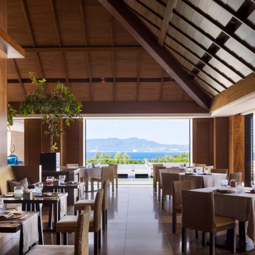 The main restaurant at The Ritz-Carlton by day, with a clear view out to the sea and surrounding mountains