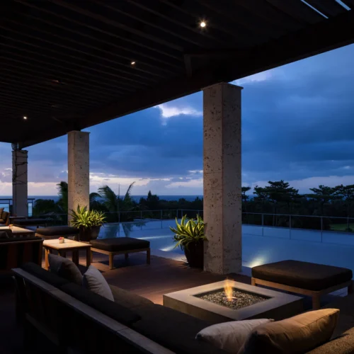 A seating area by the pool at The Ritz-Carlton by night, with small fires to keep people warm