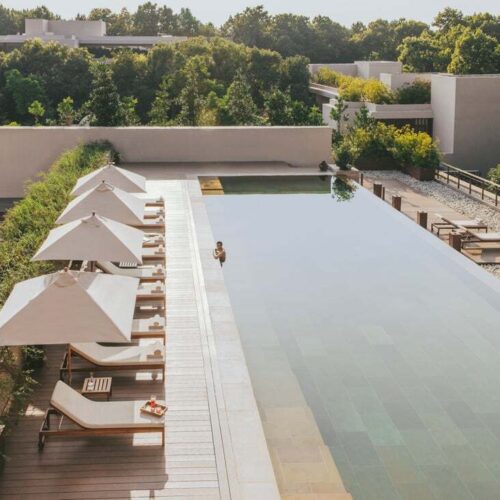 The pool area at Six Senses Vana, surrounded by deck chairs