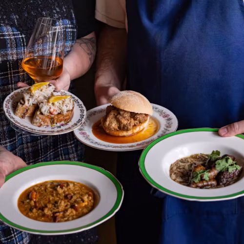 Servers carrying small plates of food at Tasca